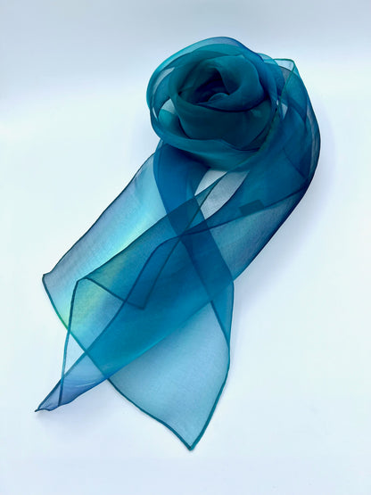Experience the perfect harmony of art and elegance with our one-of-a-kind silk scarf—a designer accessory that transcends fashion into a realm of beauty and inspiration. Handcrafted with meticulous care, each piece is hand-dyed to create a stunning interplay of multicolor tones, forming a vibrant rainbow of hues that shimmer with soft transparency. Designed to complement any outfit, from casual wear to formal dresses, this versatile scarf enhances your personal style with a touch of uniqueness. Whether worn
