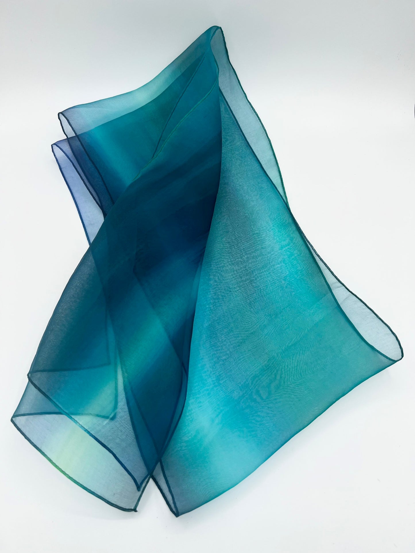 Experience the perfect harmony of art and elegance with our one-of-a-kind silk scarf—a designer accessory that transcends fashion into a realm of beauty and inspiration. Handcrafted with meticulous care, each piece is hand-dyed to create a stunning interplay of multicolor tones, forming a vibrant rainbow of hues that shimmer with soft transparency. Designed to complement any outfit, from casual wear to formal dresses, this versatile scarf enhances your personal style with a touch of uniqueness.